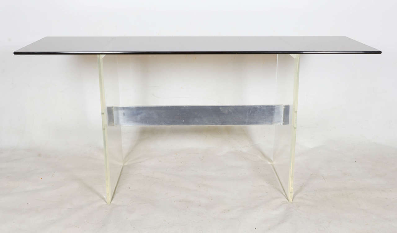 Crisp and clean design by Cy Mann. The console table has a gray glass top supported by two bevelled lucite bases. The bases are joined with a polished aluminum cross bar. Please contact for location.