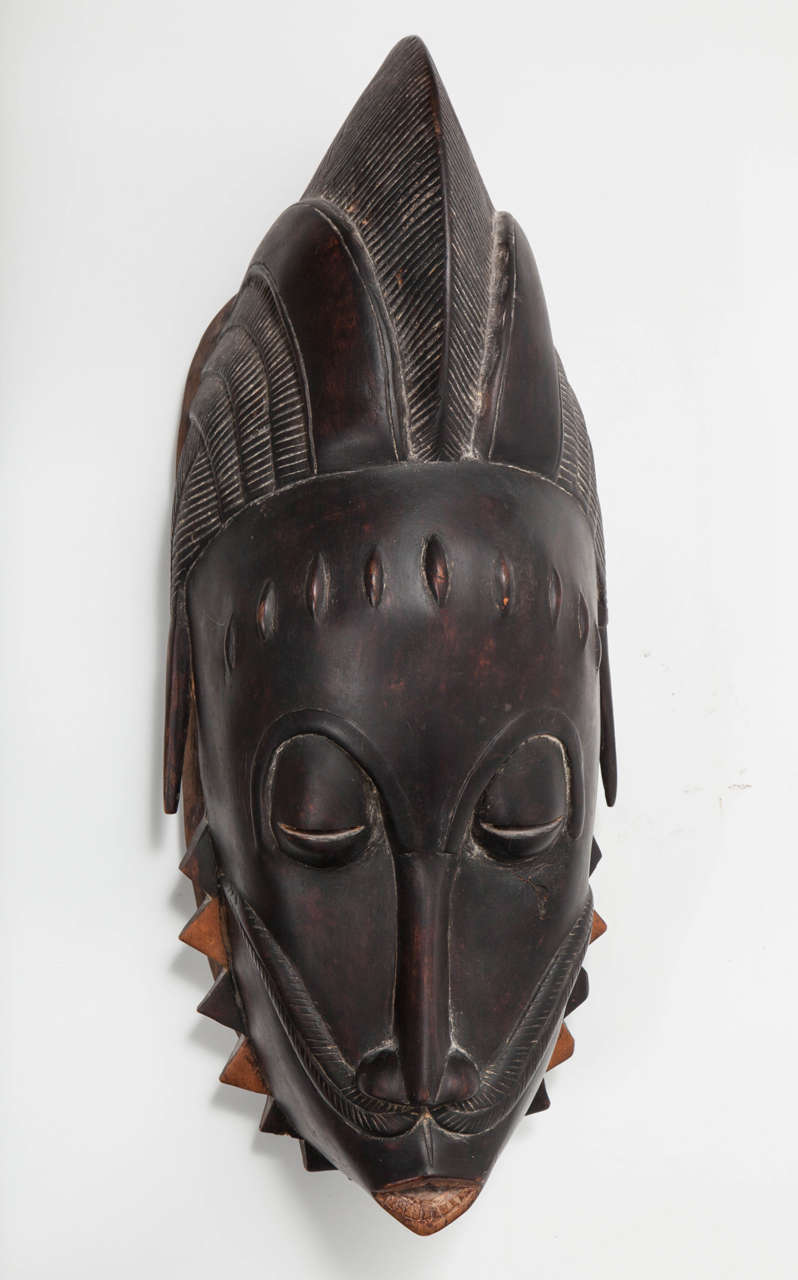 An ominously solemn tribal mask that has a thoughtful and non threatening appearance.