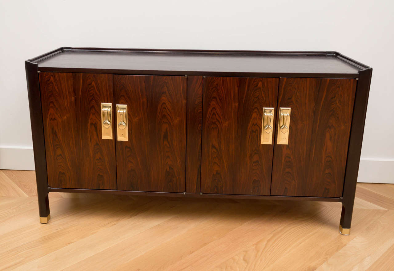 Rosewood buffet with polished brass hardware. It's kind of the perfect size if you’re limited for space.
(One door on the left doesn't close flush).