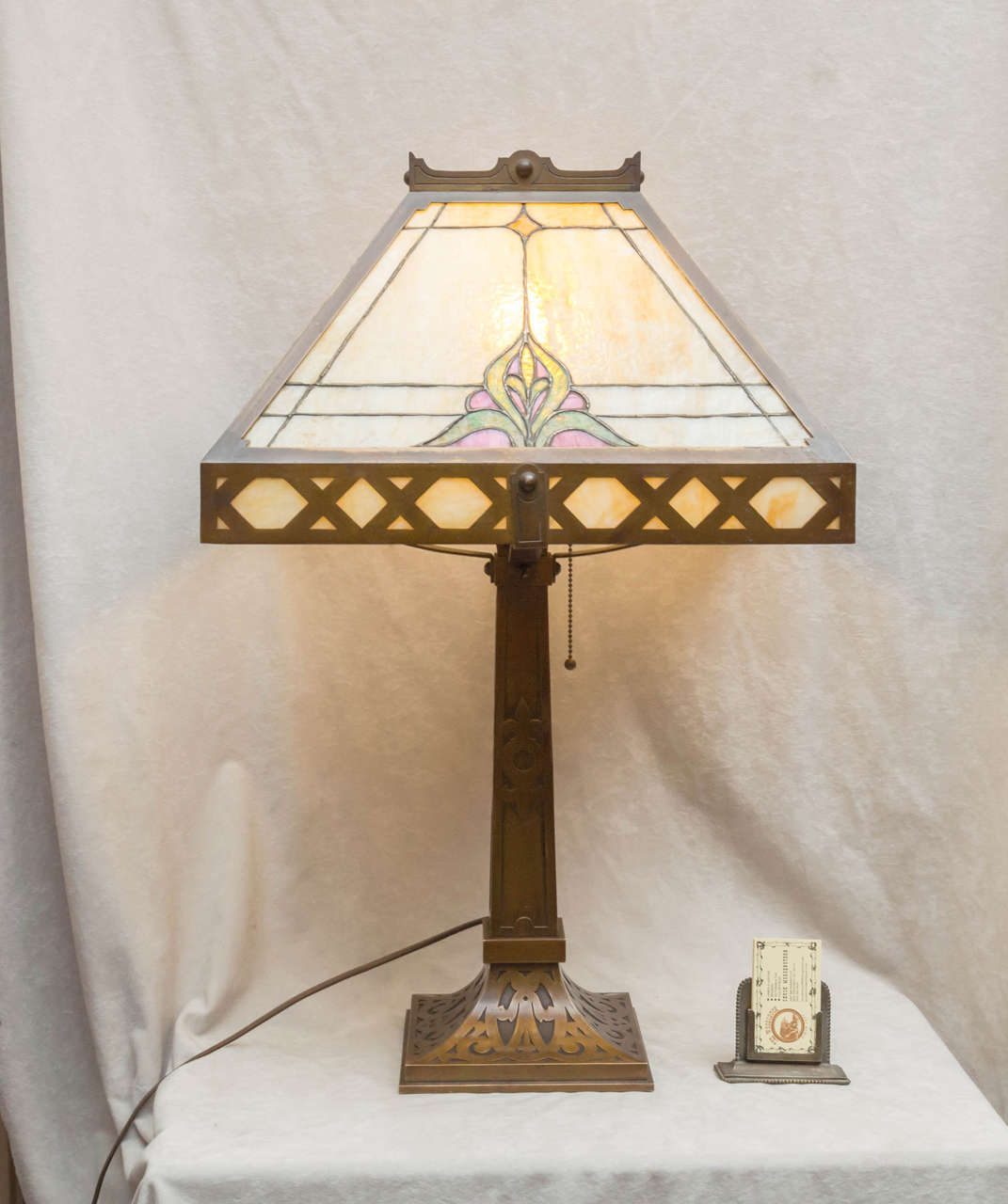 This very impressive and large table lamp is rare in that while it is a panel lamp, the glass in the panels is leaded glass. A rare and more desirable than the standard panel lamp which usually just has one piece of glass in the panel. We don't know