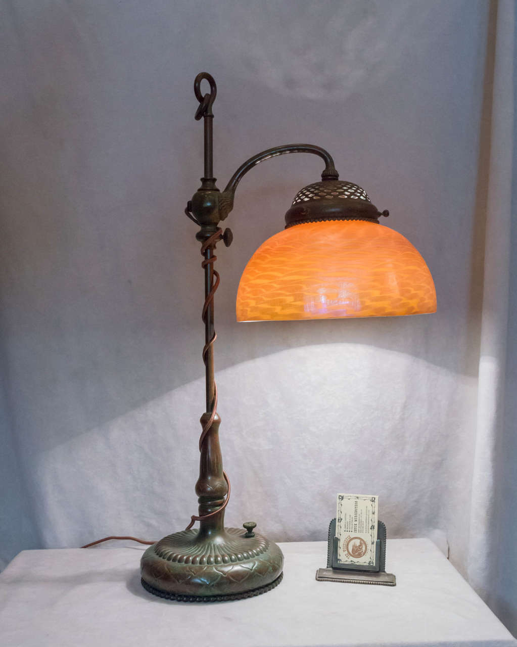 A fine example of a lamp by the master lamp maker,Tiffany. Both shade and base are signed and in super condition. The body can be adjusted as the arm can move from side to side, and there is a knob whereby you can adjust the height of the shade to