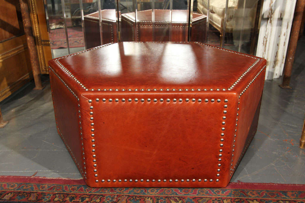 vintage ottoman newly upholstered in rich leather with nailhead trim. very sturdy for sitting or as a table top.