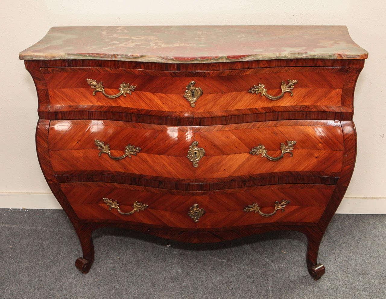 Exceptional, three-drawer, serpentine, commode veneered with pear, olive and fruit woods featuring original hardware and a new, Italian, onyx top.