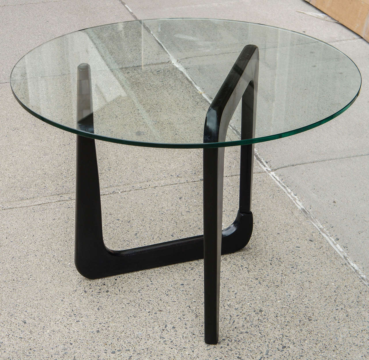 This end table design,most often seen as a coffee table, is after a design by Isamu Noguchi. Almost immediately considered a classical design of the time this table is most likely  a period reinterpretation.The piece is old without a doubt and