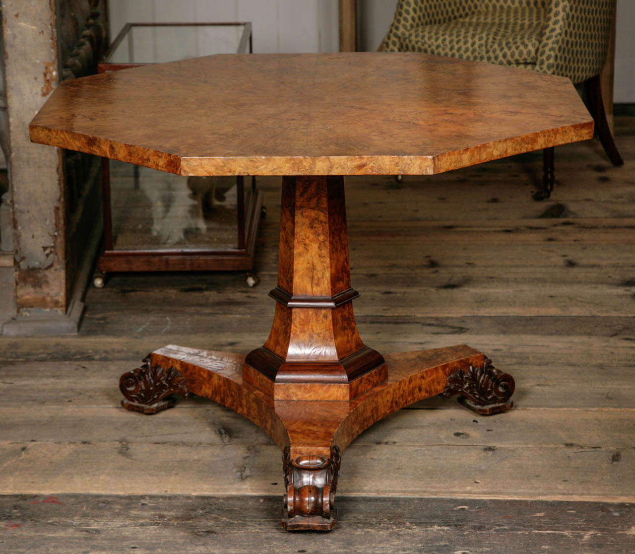 With octagonal tilt top above a tapering column on trefoil base with carved scroll feet.
