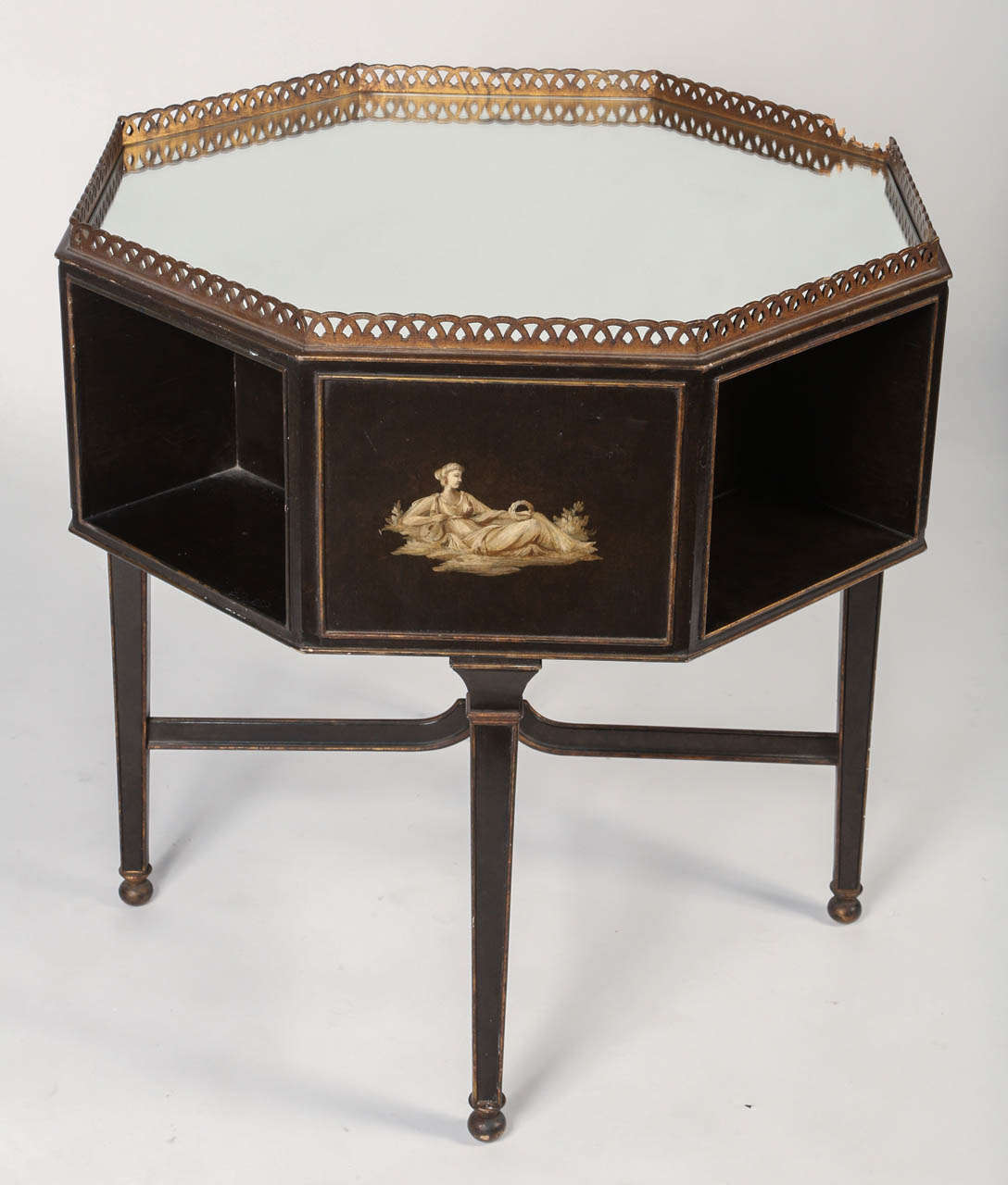 Delicate paintings adorn this mirror topped octagon-shaped table made from ebonized wood. Tapered legs with diminutive balled feet are reinforced by a finial topped x-stretcher.  This would make an elegant yet functional end table next to a sofa or