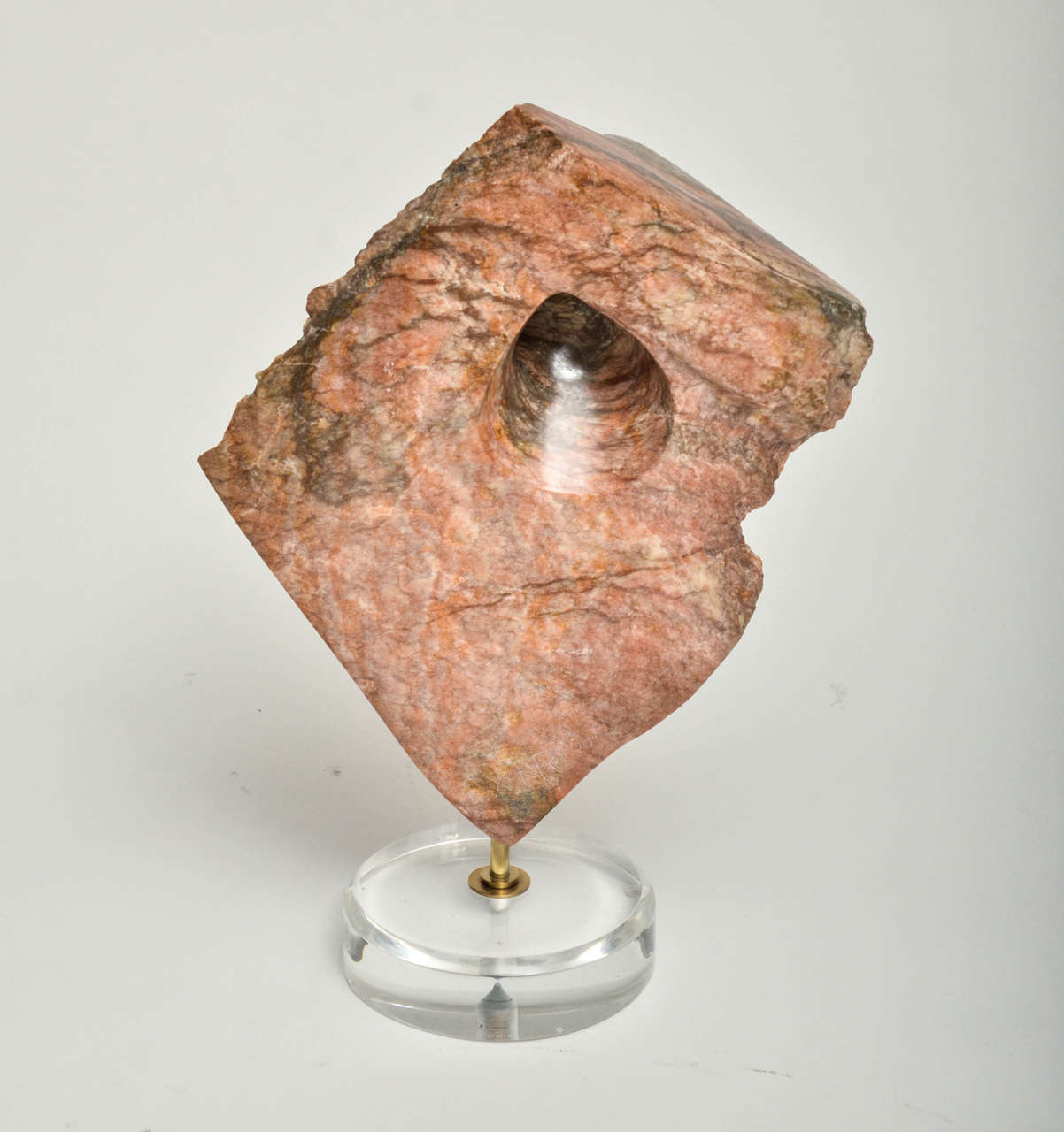 Coral toned marble abstract sculpture on Lucite base.