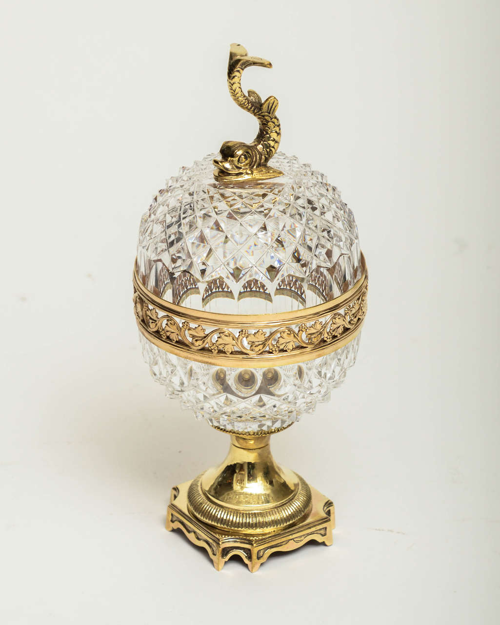 Facet cut crystal egg form box with bronze details.