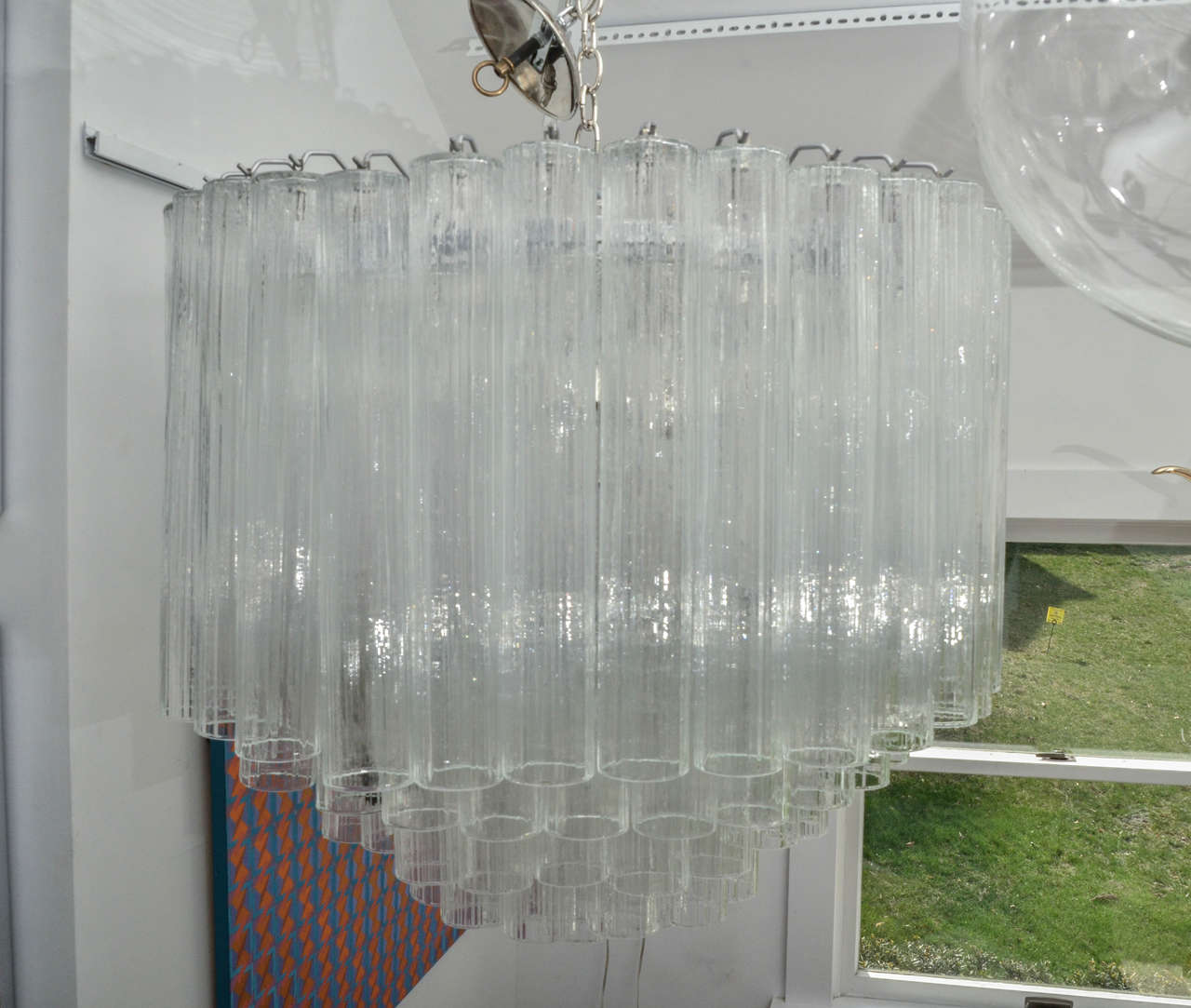 Multi-tiered chandelier composed of multiple glass tubes with nickel hardware.