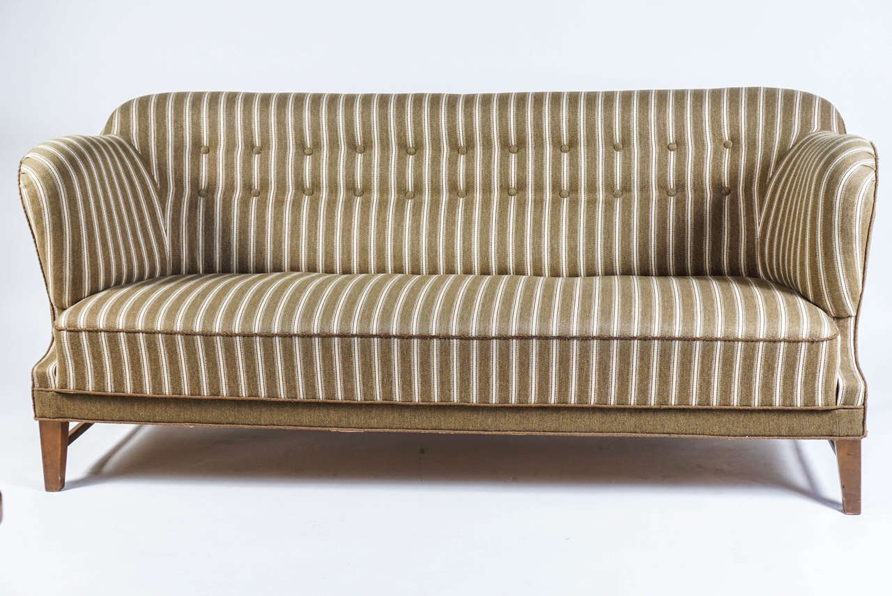 Newly upholstered in two wool fabrics: Cream and golden khaki stripe (seat, arms, and back) and golden khaki solid (shell). Tufted back and tight seat. Braided contrast welt. Nearly mint condition, minor scuffing on dark wood legs. Arm height: 30