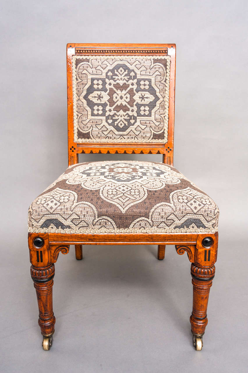A set of twelve Arts and Crafts Dining Chairs by Lamb, Manchester.
The Mahogany frames with gently scrolled toprail over a beaded frieze, flanked by four  inlaid ebony dots. With further four inlaid ebony dots either side of the lower rail. Ebonized