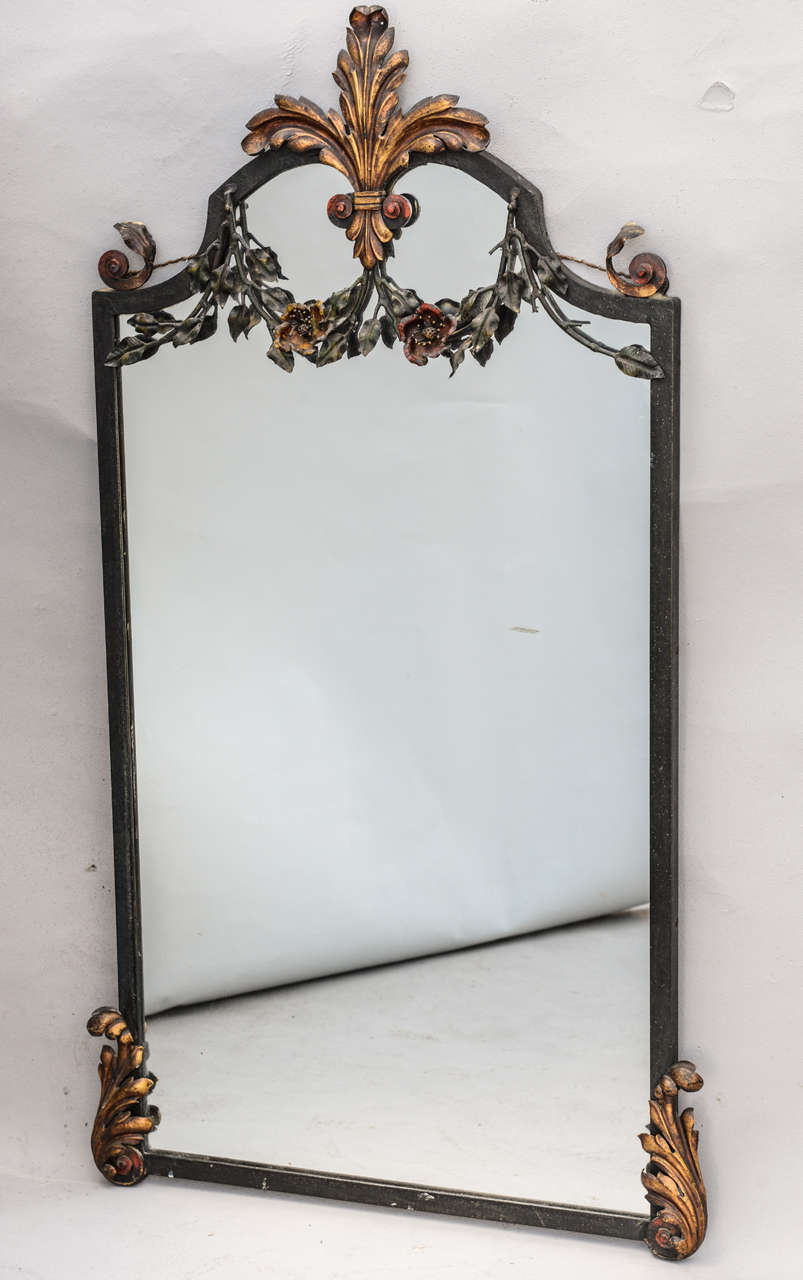 Spectacular mirror and console, having a painted and gilded finish, of finely chased wrought iron decorated by festooning and scrollwork. The console having a top of black marble. Mirror measures 41