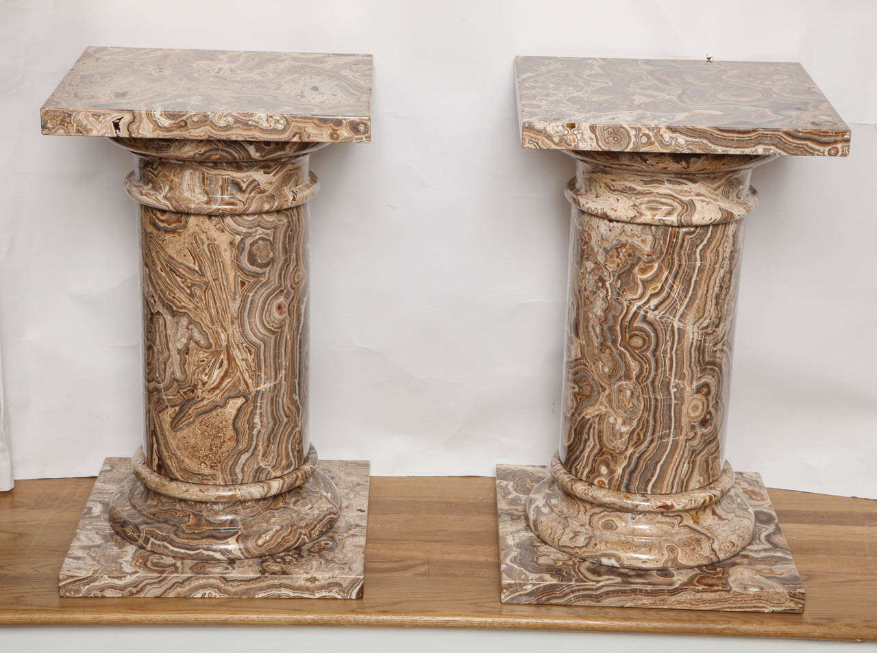 A pair of round Agate pedestals with square bases and tops.