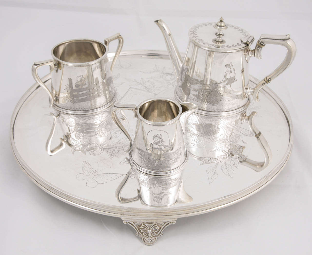 Silver plated three-piece child's tea set and tray with Kate Greenway scenes, circa 1890s, perfect for a child's nursery or given as a christening gift!
