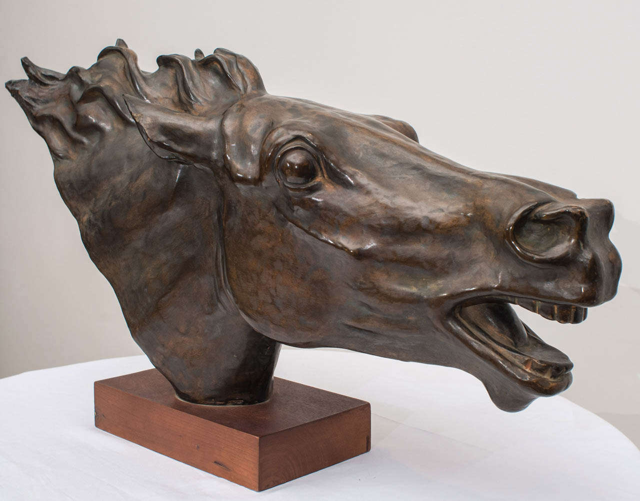 An Italian terracotta sculpture depicting the head of a running horse. The work is has a bronze overlay surface with a deep rich patina.
