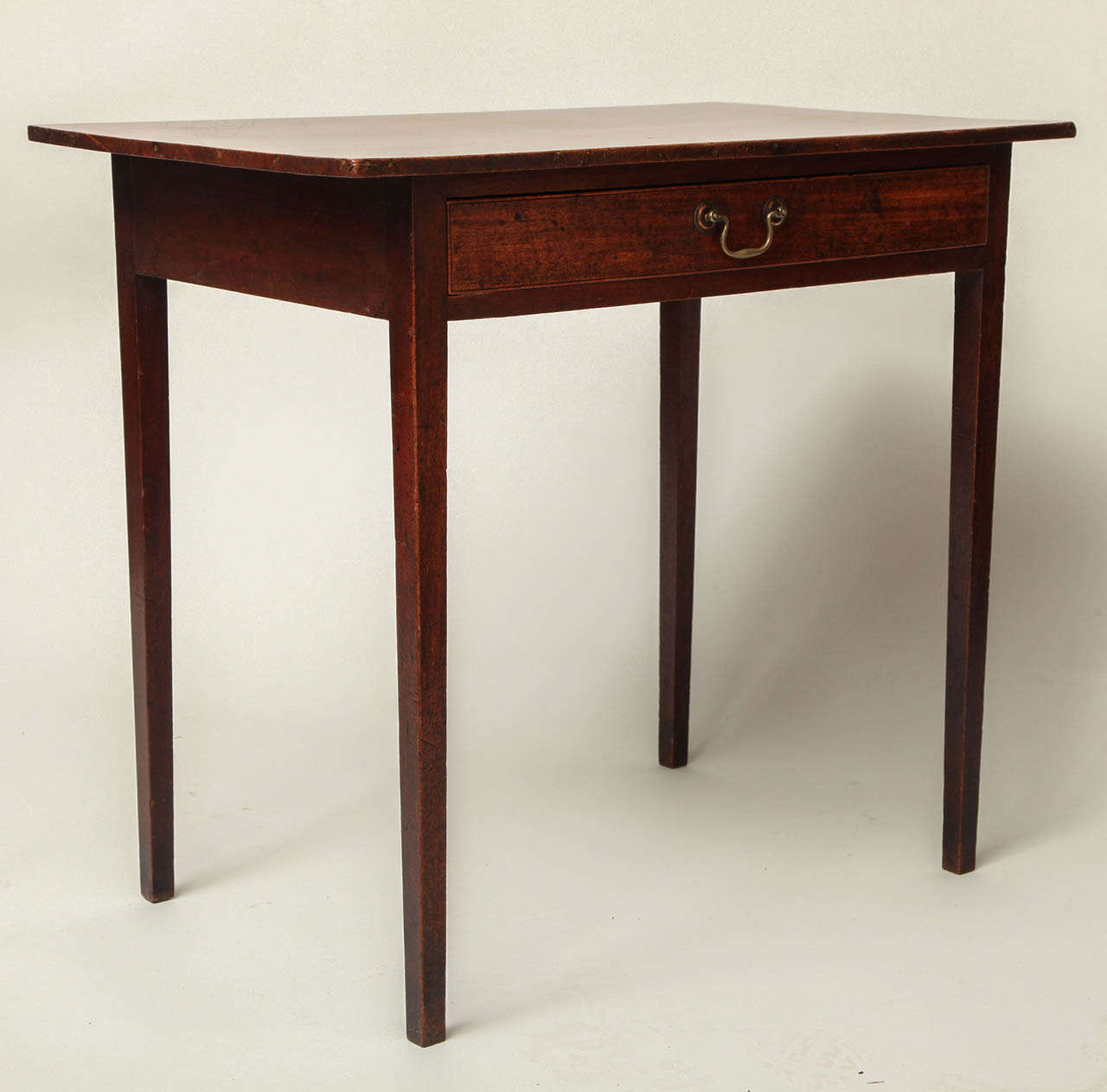 A fine Georgian mahogany side table, the single board mahogany top over single drawer having a beaded edge and original swan neck pull on square tapering legs, the whole with lovely warm color and patination.