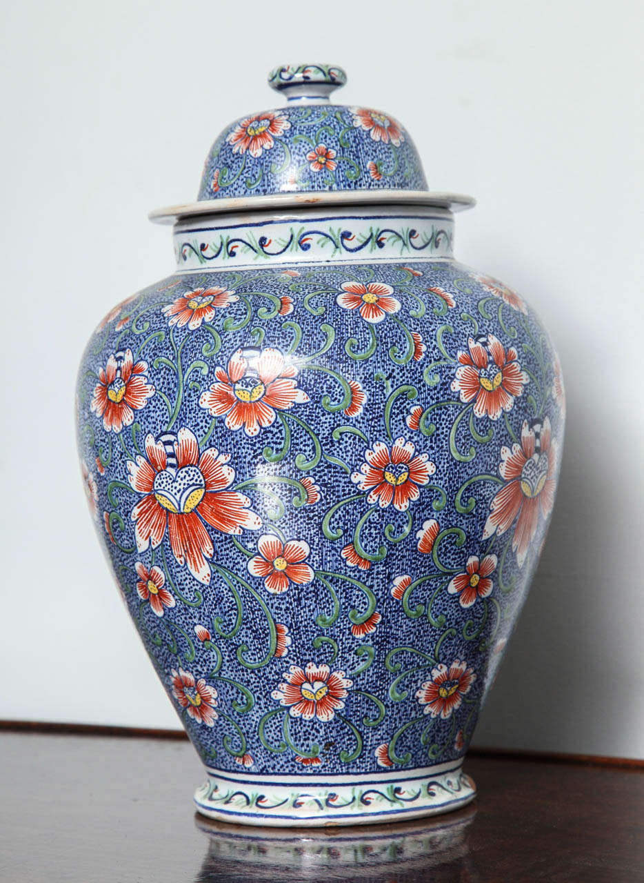 Fine 18th century polychrome delft jar having flowers on vines on a blue dotted ground, the underside with potter’s cypher.