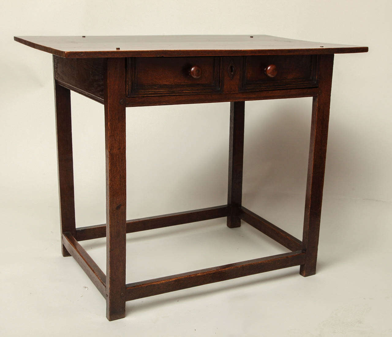 Unusual late 17th Century English oak side table, the two plank top over simple geometric molded drawer having original turned yew wood pulls and iron escutcheon, over rectangular legs joined by box stretcher, the whole with great color and patina
