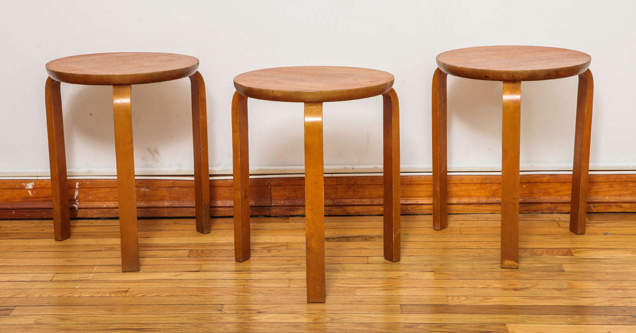 Vintage three-legged stacking stools in the style of Alvar Aalto. Made in teak with birch bentwood legs and marked 
