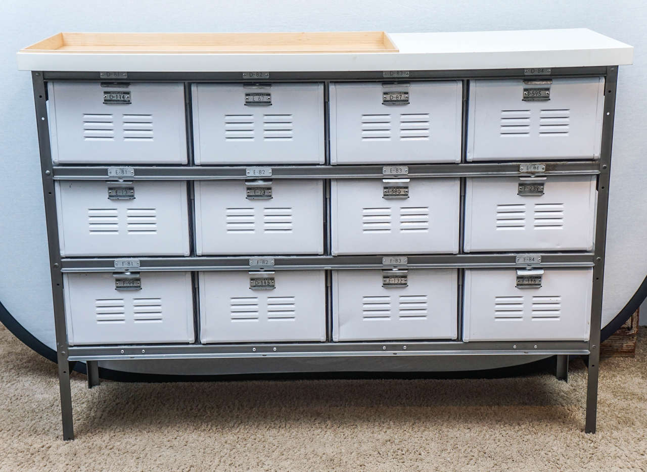 Wonderful 1970's storage unit with twelve individual bins/drawers. This unit can be used in a variety of settings; ideal in a bedroom, kitchen, nursery, etc. The top has been altered to accommodate lighting, storage or even a changing table pad.  In