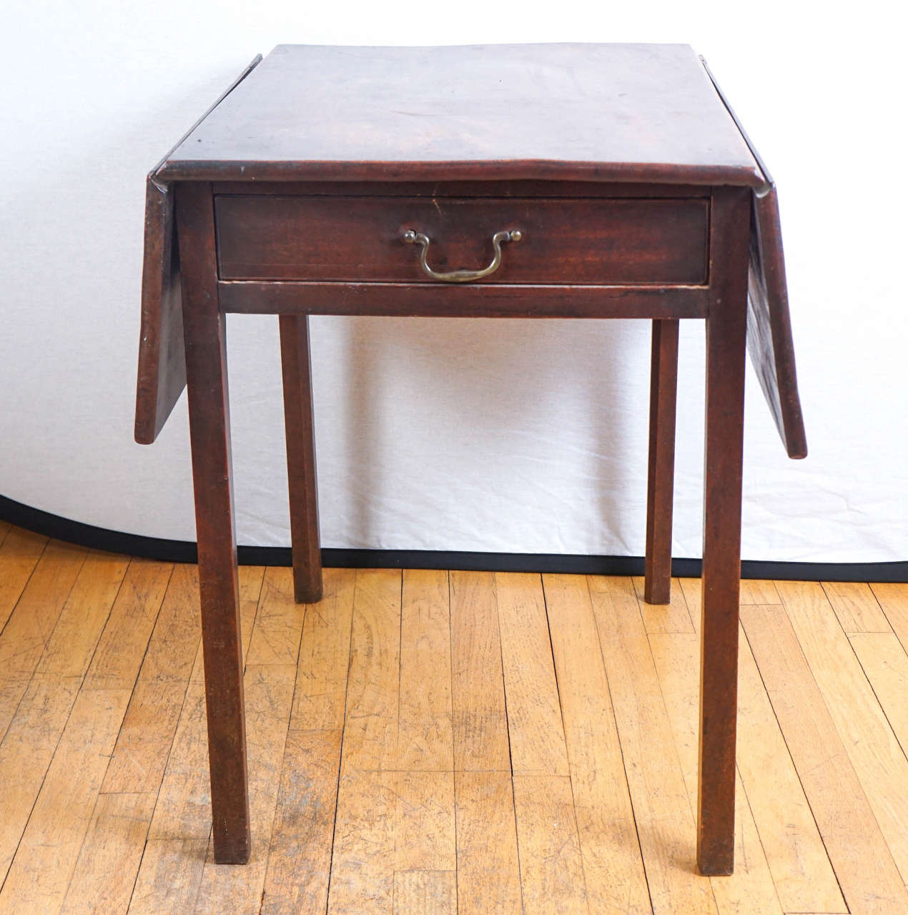 It's all about the wood! The richness of mahogany will not get lost here. This very old piece has one end drawer with original brass handle and would be a stunning end or side table in any room in the house. It works beautifully and has no flaws.