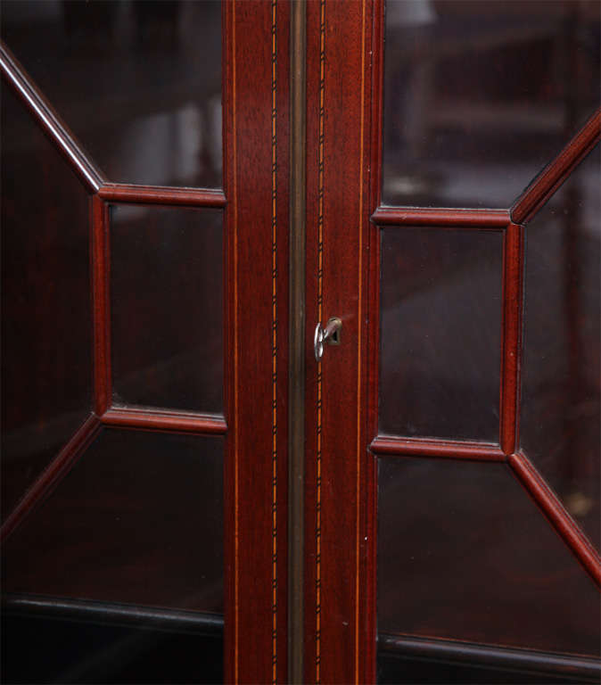 SCHMIEG & KOTZIAN
Two doors cabinet in mahogany with inlaid details. Two glass doors with wood tracery and two wood shelves. Executed by Schmieg and Kotzian, New York City.
American, c. 1910.

PROVENANCE: Estate of Frederick E. Kotzian