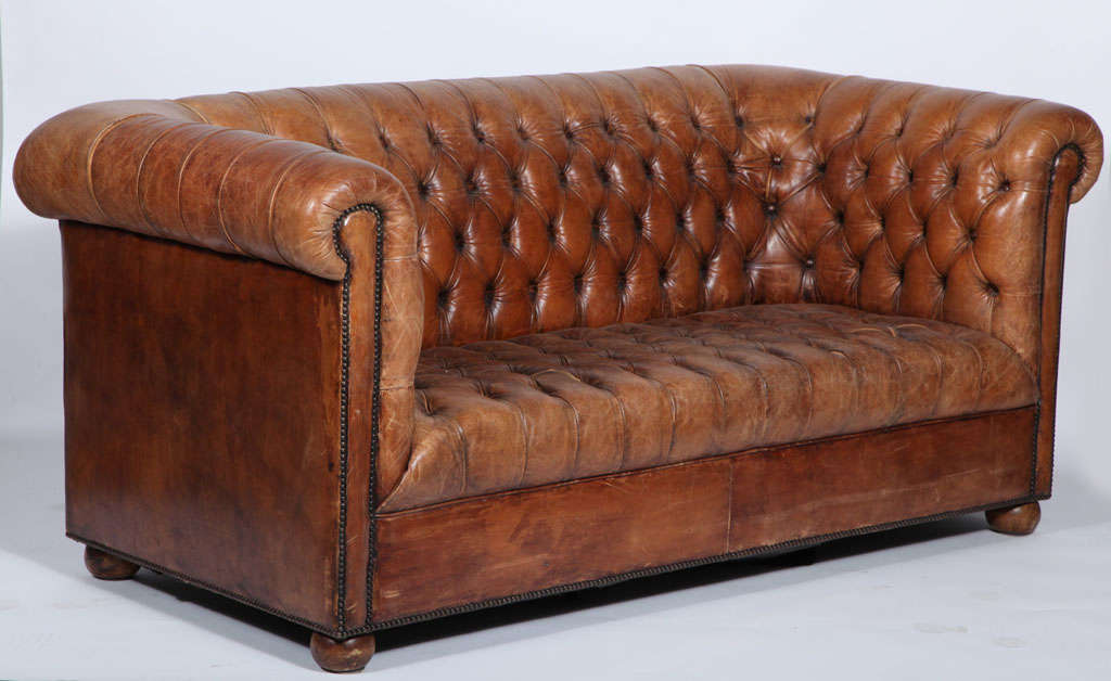 Classic leather tufted Chesterfield sofa with bun feet and nailhead trim detail.