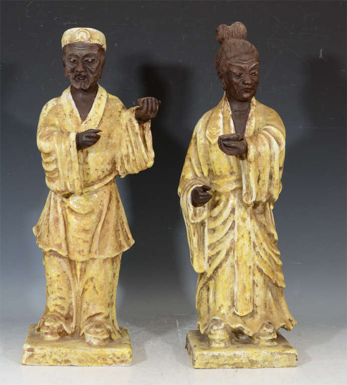 A pair of vintage Italian ceramic sculptures depicting two "sage" like figures in yellow robes. They are by Marcello Fantoni and are signed under the base.