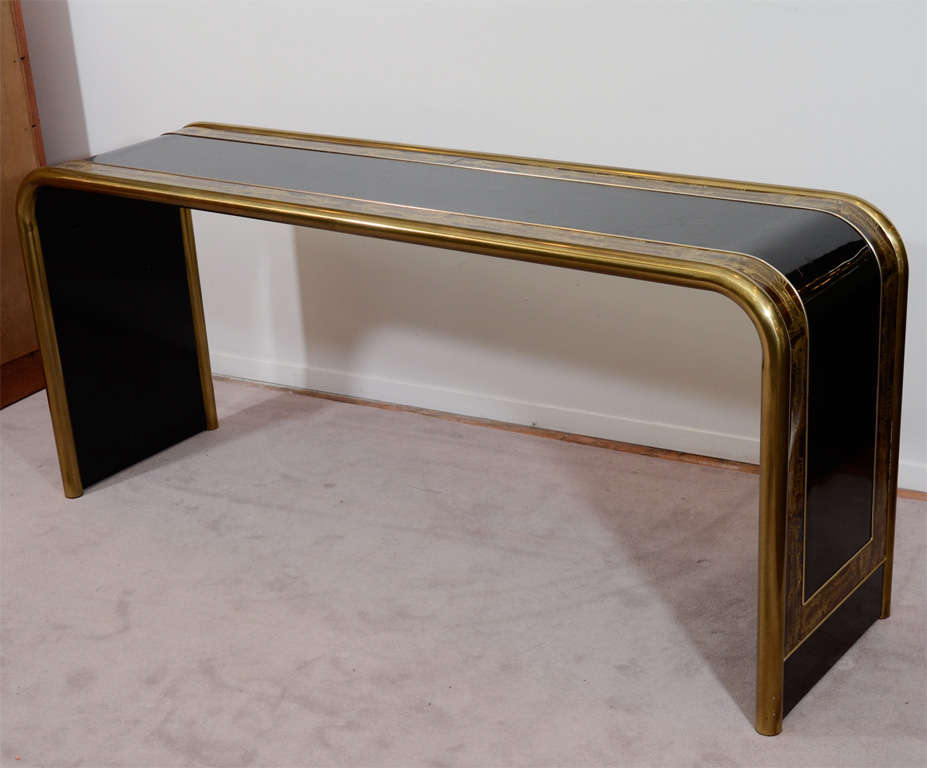 A vintage waterfall console with acid etched details by Bernhard Rohne for Mastercraft. The piece is in black lacquered wood with brass.