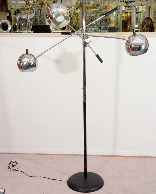 A vintage chrome and black enameled floor lamp by Lightolier. The piece has three articulated globe lamps that pivot and rotate on their arms

Reduced from $2800.00