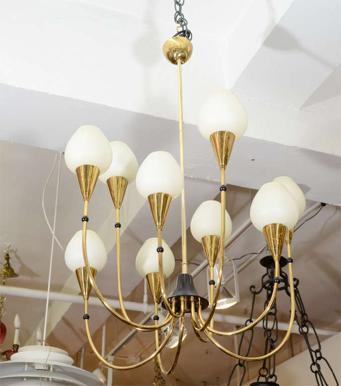 A vintage Austrian brass chandelier with nine lights of varying height. The piece has black enameled metal detailing and frosted glass shades.