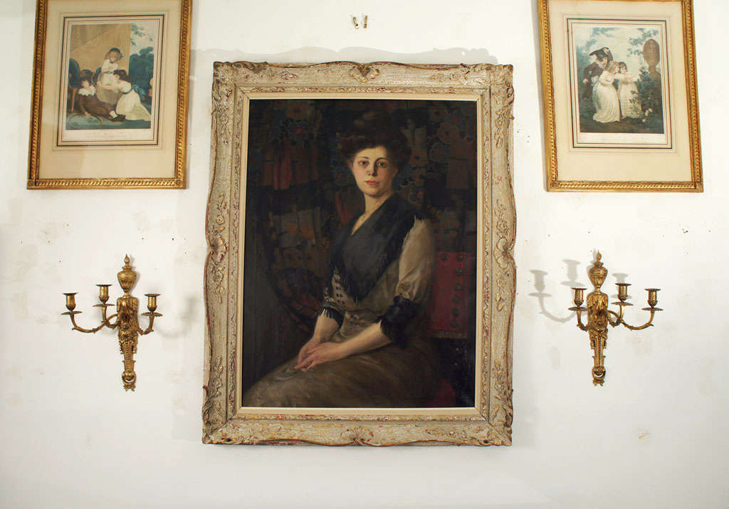 This life-size portrait of a serene beauty with “Gibson-girl” appearance is signed by well-documented German-American artist Rudolf Carl Mueller. Based on the subject’s hair style and attire and the furnishings in the background, together with the