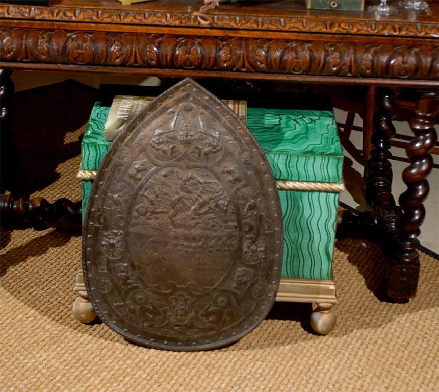 Bronze shield with Etruscan battle figured reliefs within a decorative medallion.