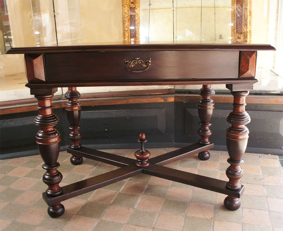 This finely detailed table made to emulate furniture from the 17th century was a product designed to bolster pride and place in the antique traditions of the past. Made from Walnut which has been stained to simulate more exotic woods the overall