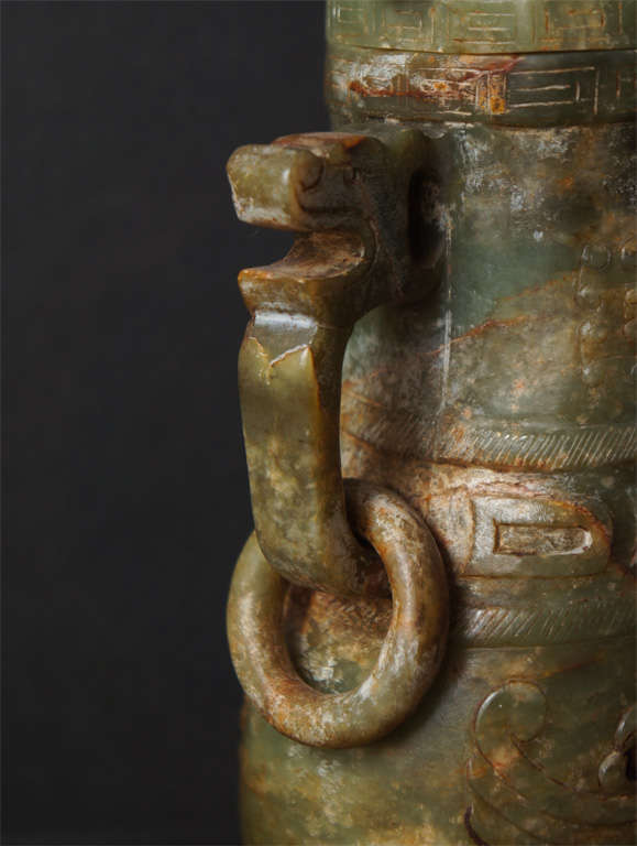This fine Jade carved vase has been made to correspond to  Chinese bronze vessels used in rituals from China's ancient past. The form is accentuated with low relief carvings of small repetitive cones and interconnecting line similar to those found