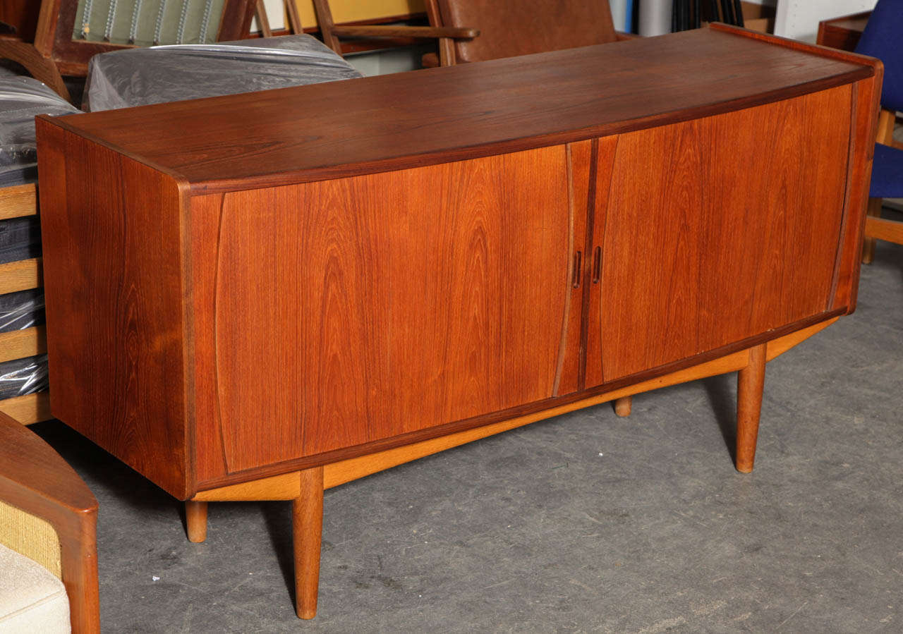 Vintage 1950s Danish Credenza with Sliding Doors.

This Vintage Sideboard is quite unique and beautiful with it's bowed-out front. The doors are called 'tambour doors' which means they doors slide back behind the piece which is a very elegant