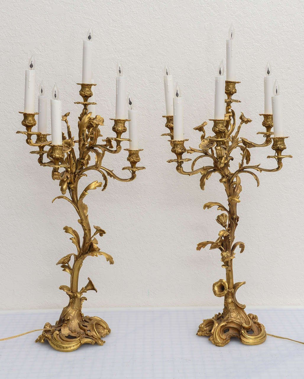 Pair of French candelabras with very detailed composition.  Each has six radiating candle arms with wax sleeves, currently wired but could be removed & used with candles.