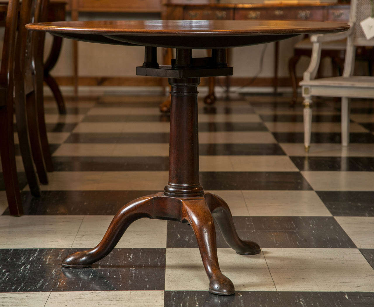 While there is nothing extraordinary about this mahogany tilt-top table no fancy, carved edge or claw and ball feet there is nothing particularly ordinary, either. The top is just the right thickness for the diameter and the pedestal is weighted