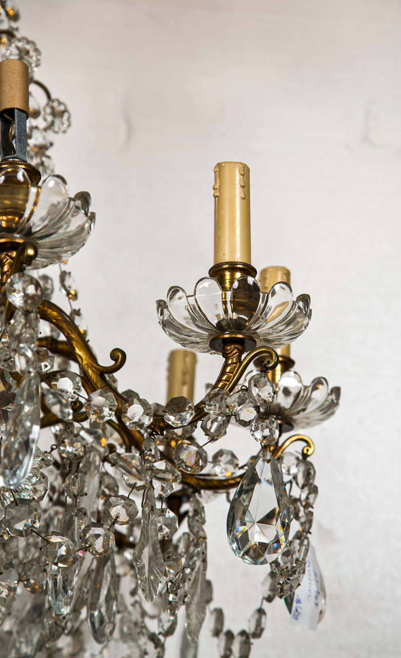A fine cut glass Georgian Style Crystal central column and bronze chandelier. This twelve light candelabra style chandelier possiblly waterford or baccarat crystal. The crystal bobeshes under finely cast bronze lights. The overall design very