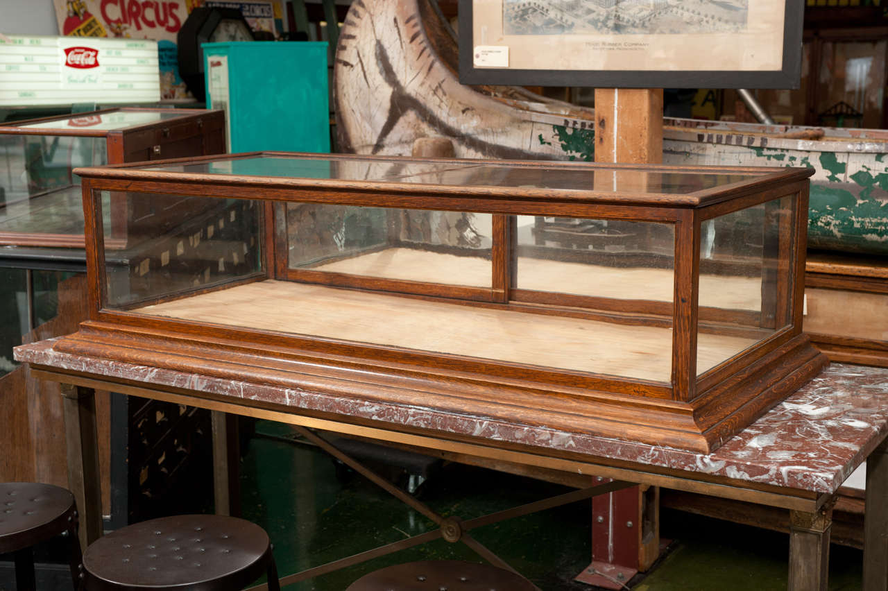 Rectangular glass topped oak counter showcase with sliding original mirrored doors. All wood casing and bottom, original glass.