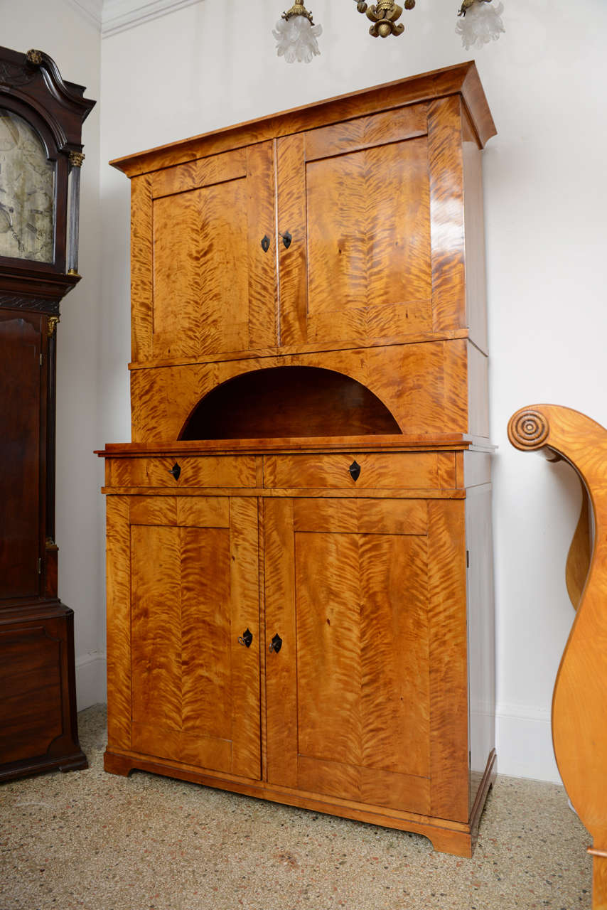 Biedermeier Cabinet/ Hutch, Two-part, Flame Birchwood, ebonized escutcheons, original restored finish.  

In Central Europe, the Biedermeier era refers to the middle-class sensibilities of the historical period between 1815, the year of the