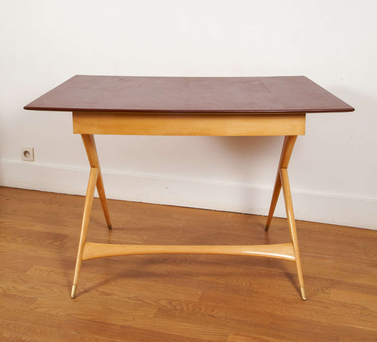 Sycamore desk with Brown leather gained top, by Jules Leleu, 1959.
Curved rectangular shape. Compass base. One central drawer.
Gilt bronze sabots. Signed and numbered.
Front width 106 cm.