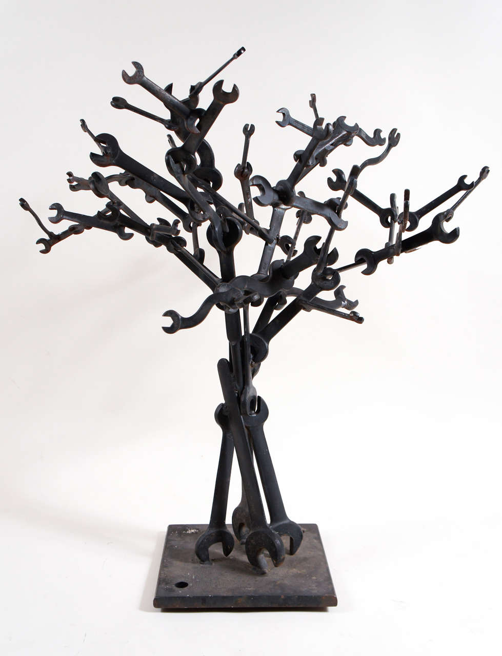  a collection of wrenches arranged in tree form - mounted on a steel base -  painted black - with traces of rusting - found at auction in western Mass. - only art piece in gentleman welders home