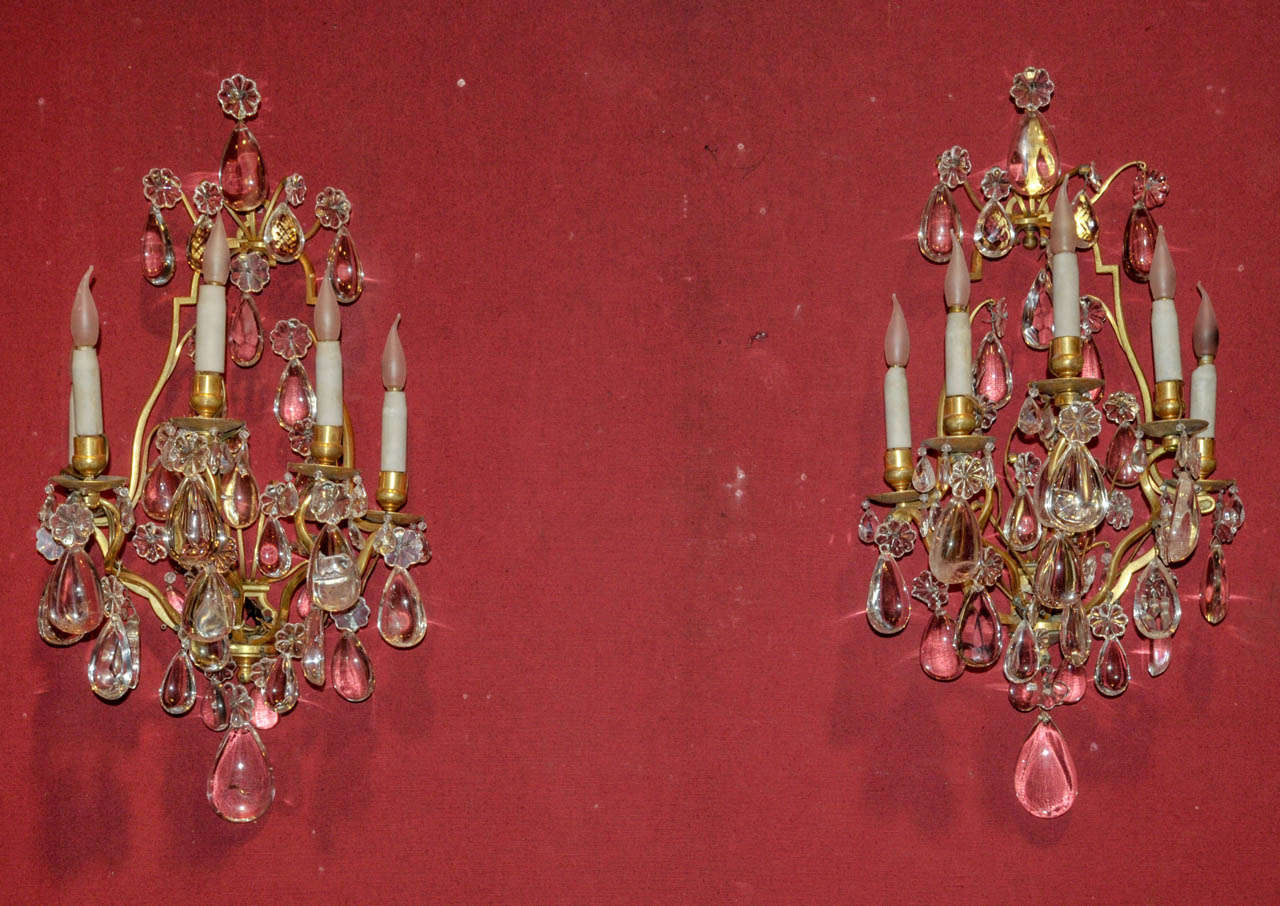 Pair of 1880's Regence style sconces in gilded bronze and rock cristal. Five lighted arms. Wired for European use.  Good condition. Normal wear consistent with age and use.