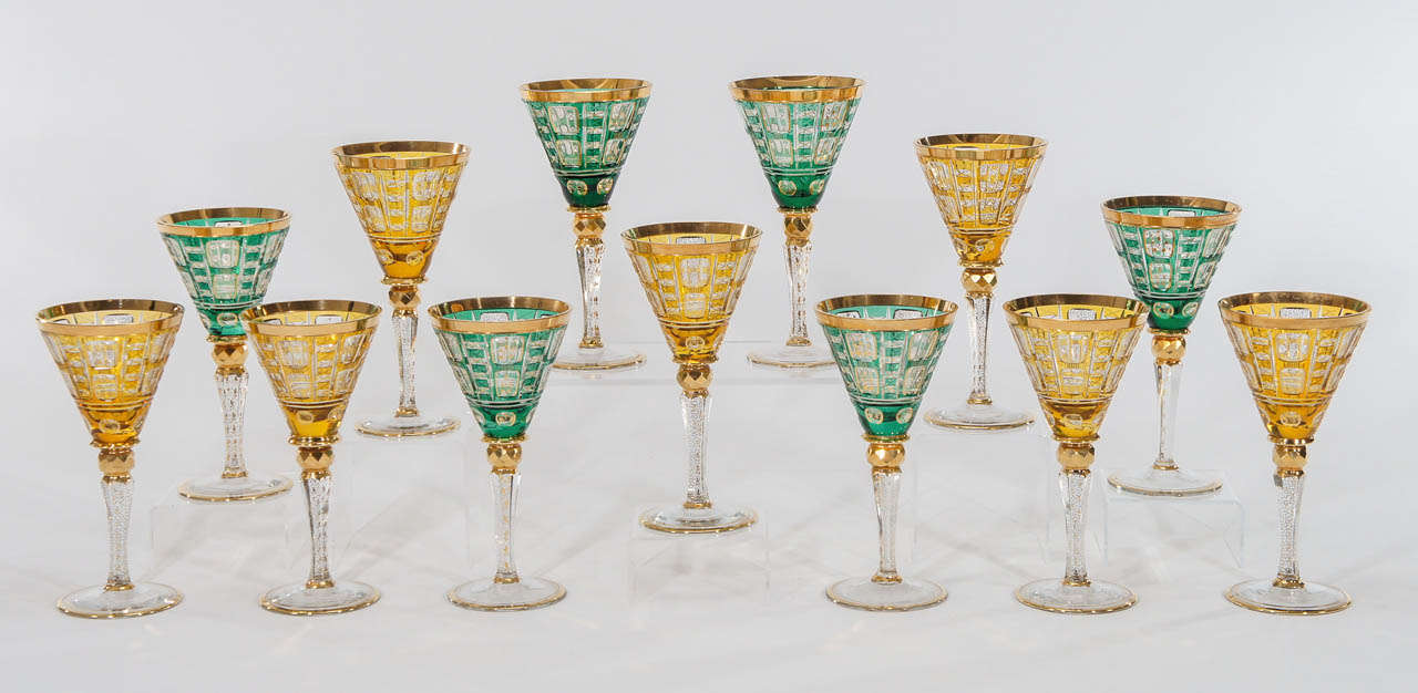 A set of tall and imposing, hand blown crystal goblets in complimentary colors, emerald green and amber. Each goblet is  cased and cut to clear and beautifully embellished with gold enamels. Standing tall, they set the tone for an elegant and regal