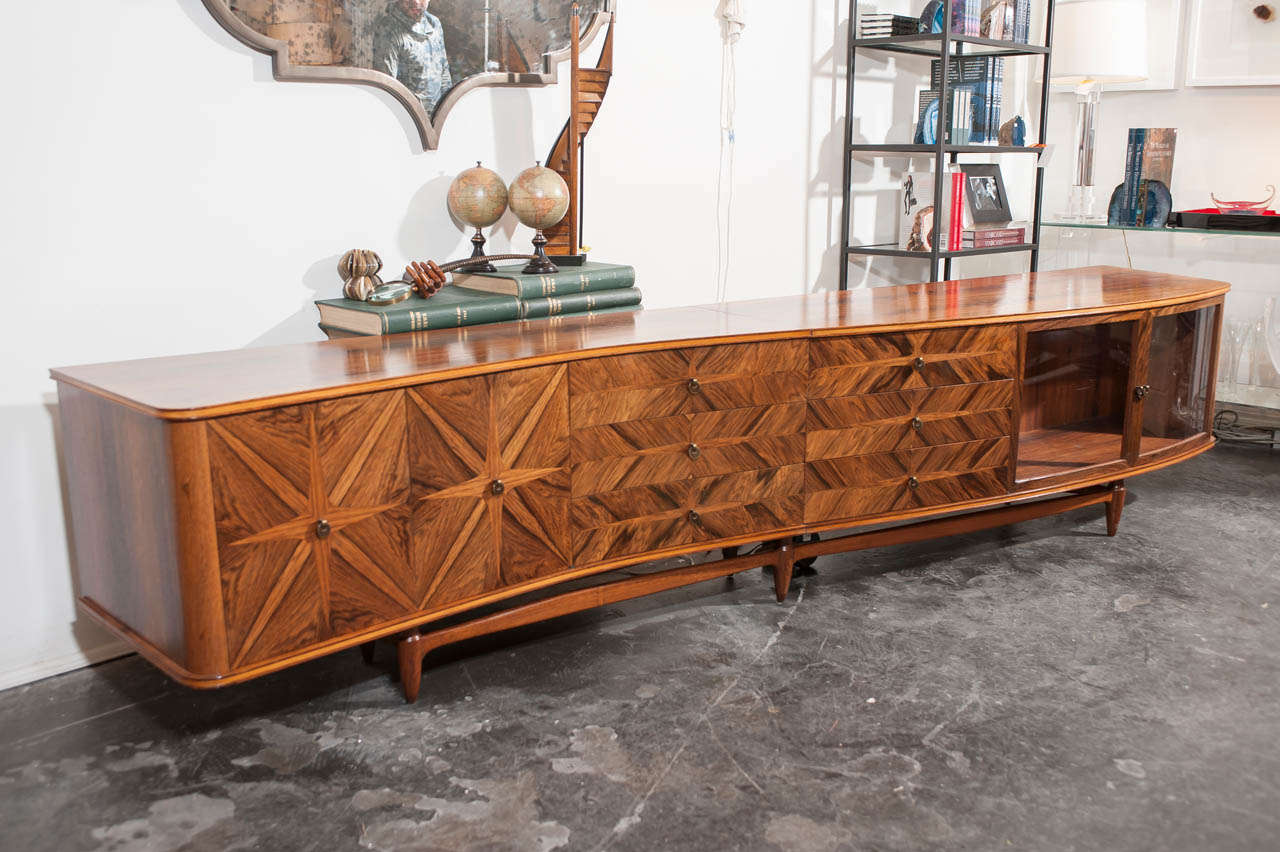 This stunning Vintage American 1960s Serpentine Sideboard is comprised of matchbook mahogany veneer and is a one of a kind custom piece. Carefully sectioned into two pieces that link together flawlessly to create one 10 foot long sideboard that