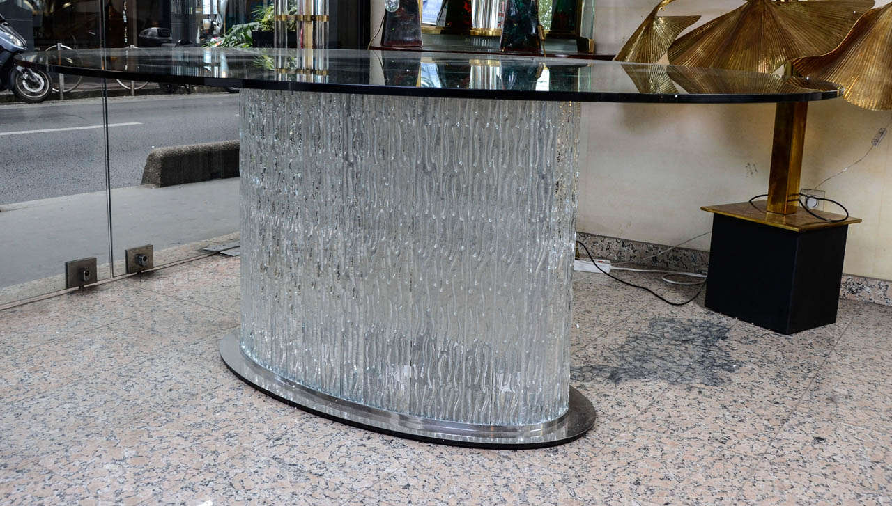 big dining table  in glass and metal.
the base is illuminating, form with different pieces of glass, each one attached with screws.
the metal have been entire restored.