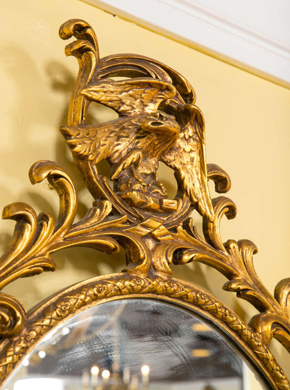 Georgian Style Gilt Exquisitely Carved Oval Mirror Adorning a Winged Eagle In Good Condition In Stamford, CT