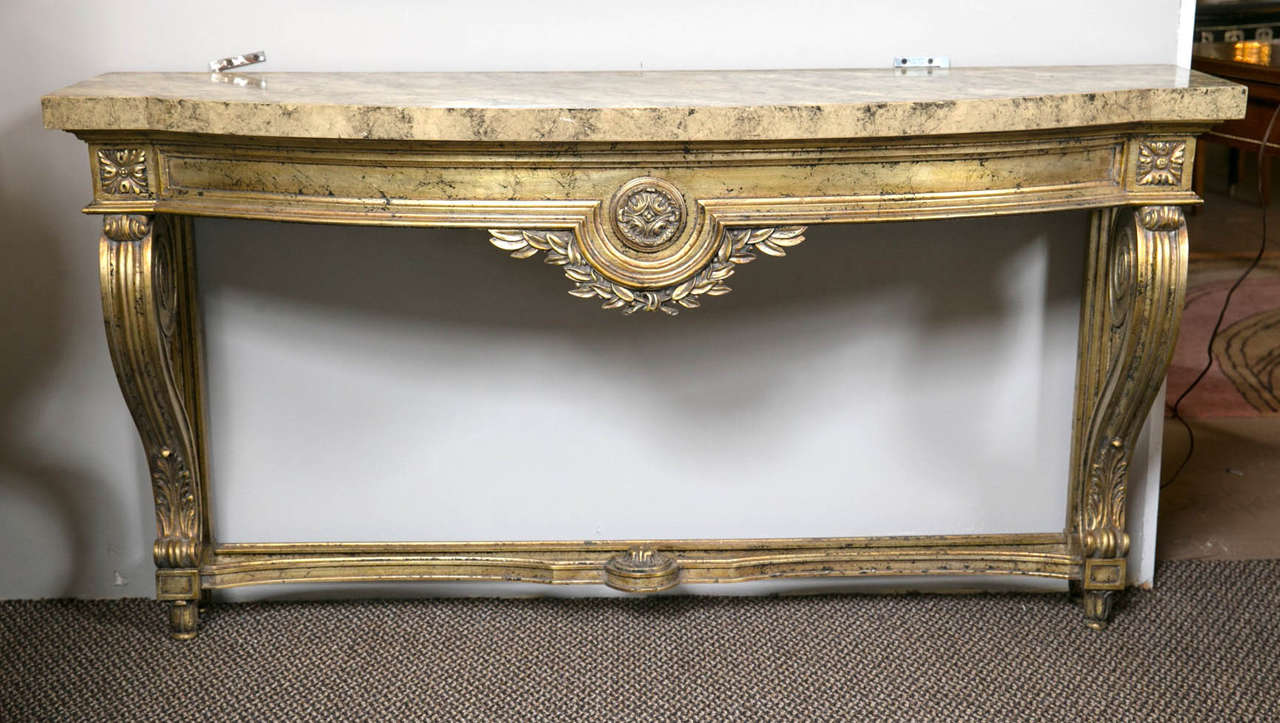Faux marble-top Louis XV style console table attributed to Maison Jansen. This finely distressed silver goldish leaf console is very decorative. The wonderfully painted faux marble wall mount sits atop a case with a central leaf and vine decoration