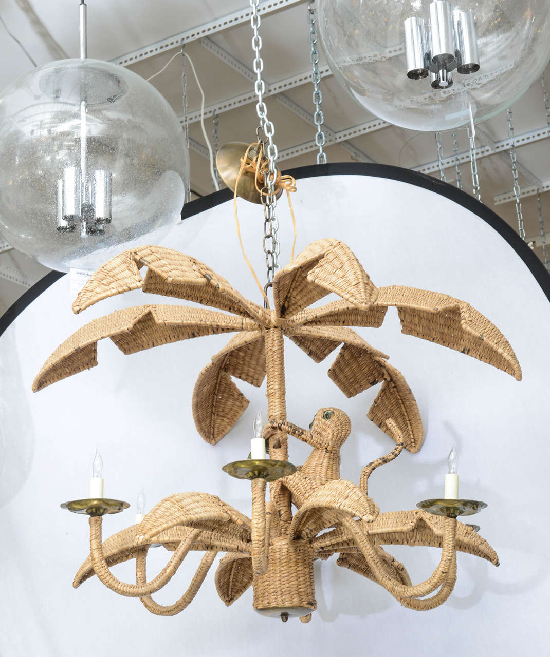 Whimsical wicker and mixed metal monkey chandelier by Mario Lopez Torres for Tzumindi. Body height of the chandelier measures 25.5 to the top of the metal loop projecting from the top of the palm tree.
